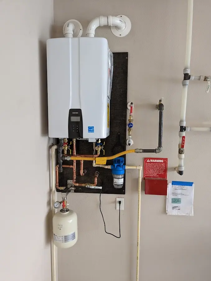 Professional plumber installing copper piping in a Fortville home